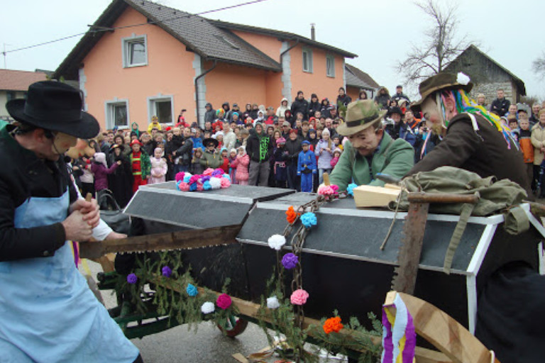 Zagoriške mačkare performing traditional Carnival ritual in Slovenia with symbolic coffin and crowd in background
