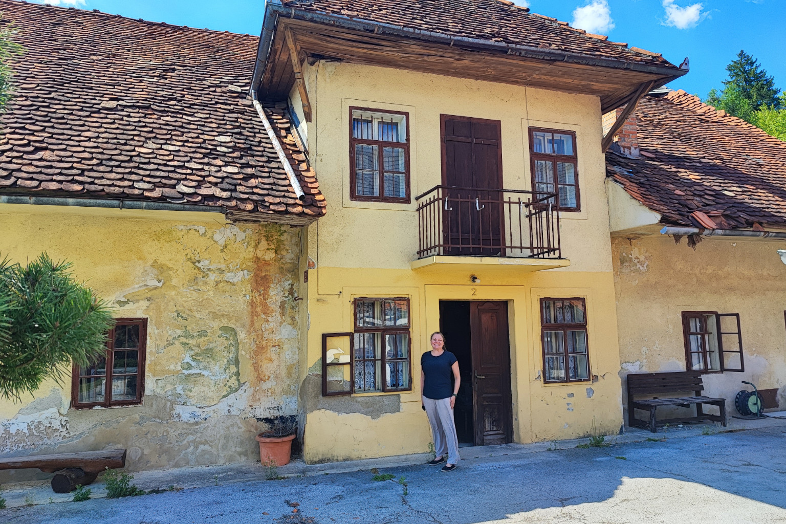 Pam Cesen standing at the entrance of the ancestral Česen family homestead in Slovenia
